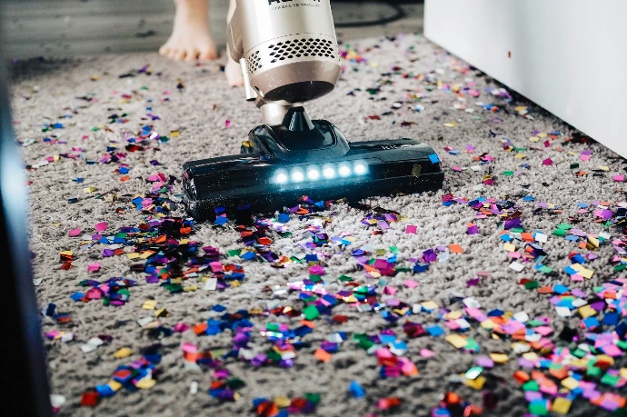 a person using a vacuum to clean a carpet
